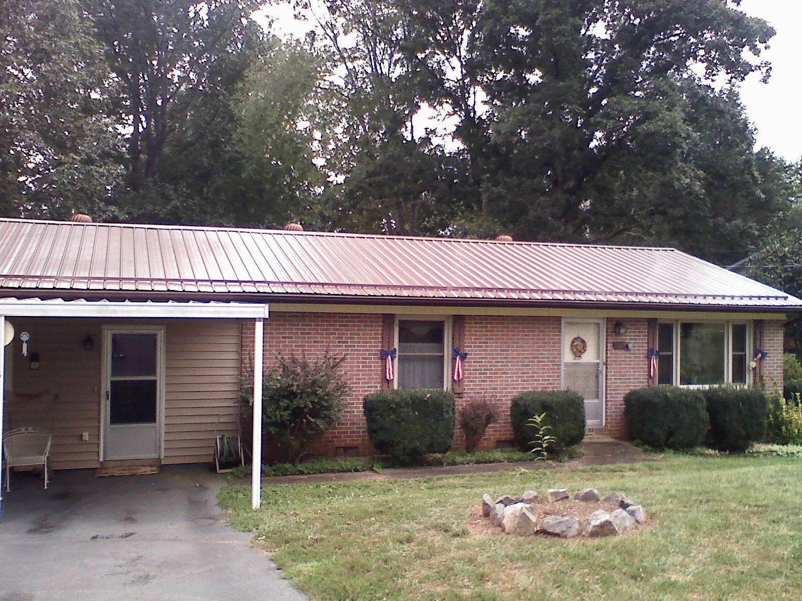 Bronze metal roof and carport on a brick ranch home — Roof Repair work by our crew in Olivia